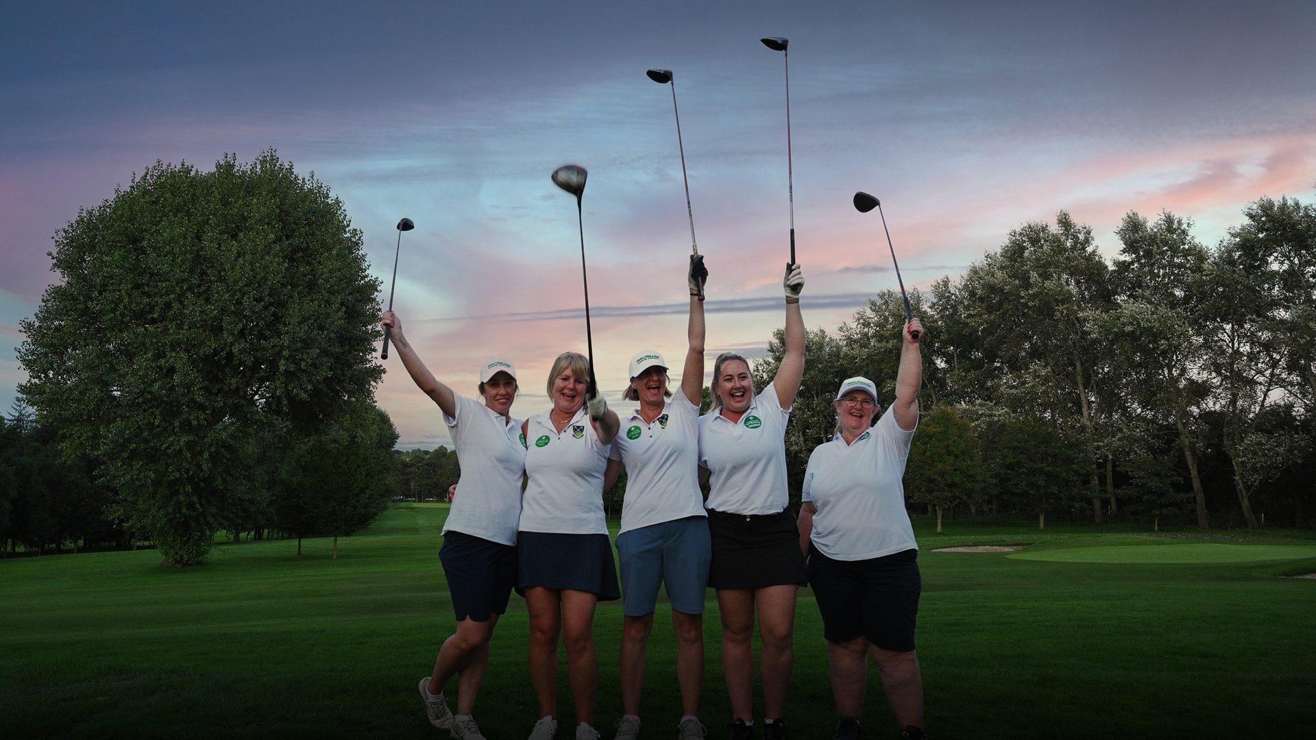 A group of women posing for a photo on a golf course.