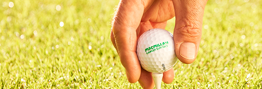 Hand holding a Macmillan Cancer Support branded golf ball