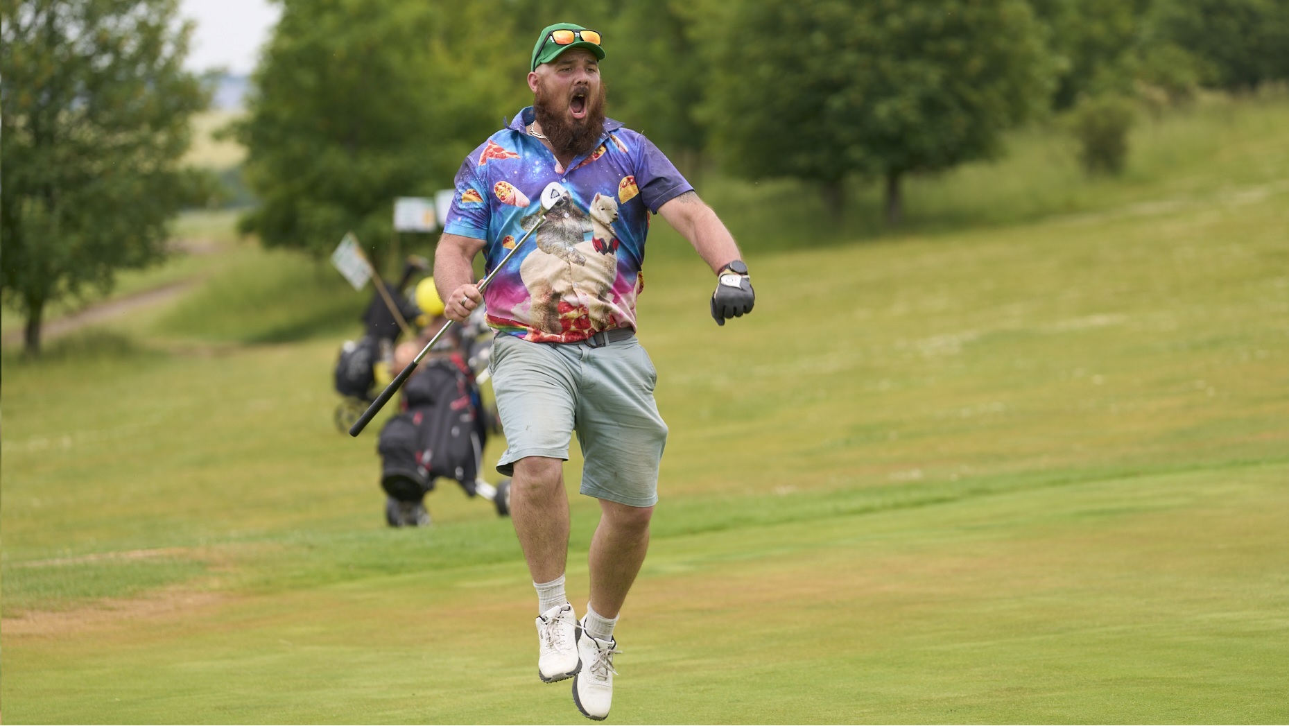 Aman in a colourful shirt celebrates on a golf course