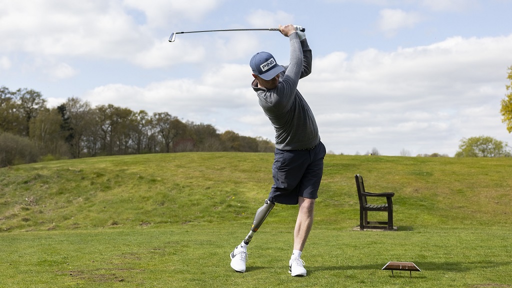 Male golfer with a prosthetic leg taking a shot